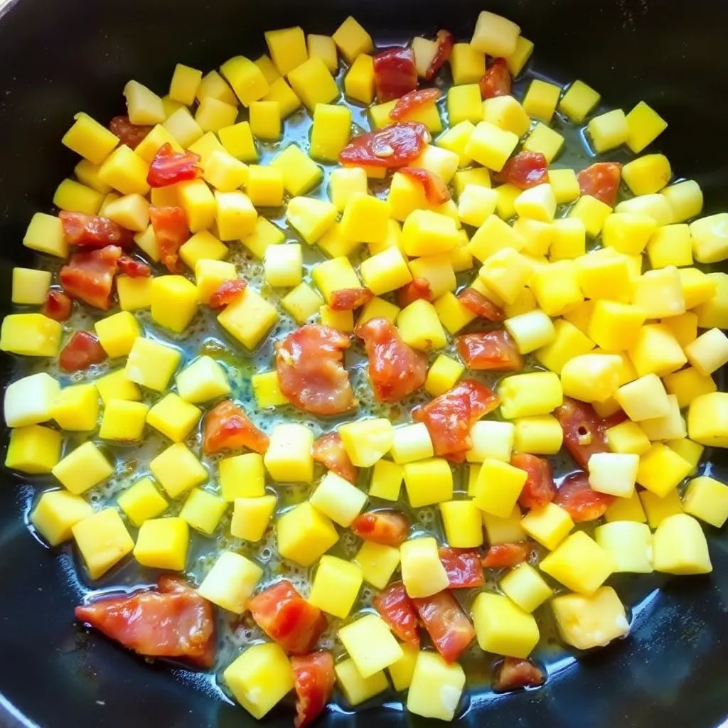 A skillet filled with golden corn kernels sizzling in butter and bacon fat.