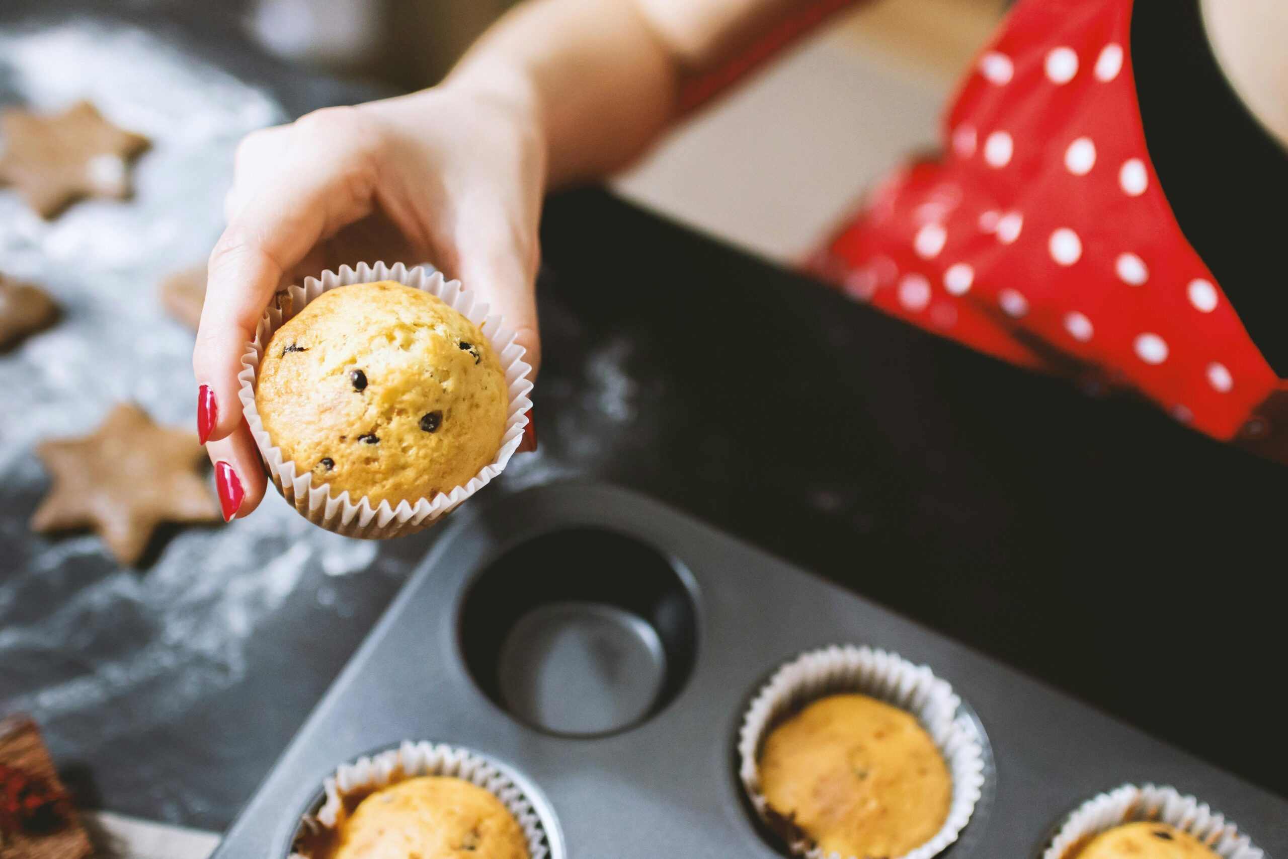 A close-up shot of freshly baked sausage muffins with melted cheese oozing over the top.