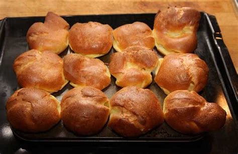 A traditional roast beef dinner with Yorkshire puddings, gravy, and steamed vegetables.